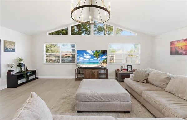 a living room with furniture a flat screen tv and a large window