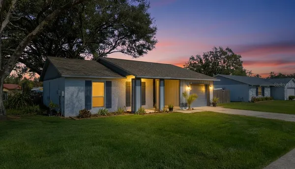 a front view of a house with a yard and trees