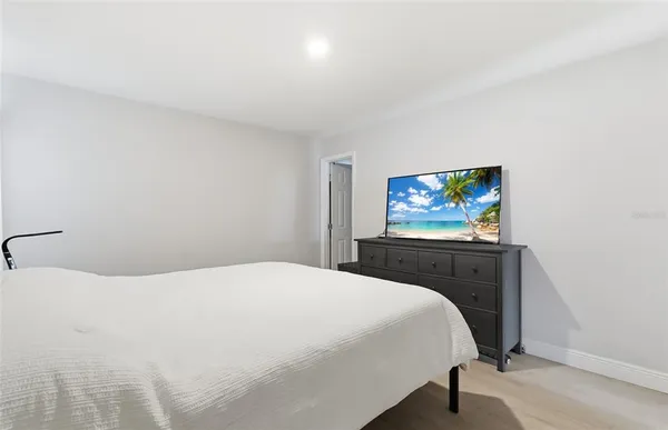 a bedroom with a bed and a flat screen tv