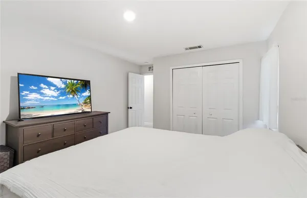 a bedroom with a bed and a flat screen tv