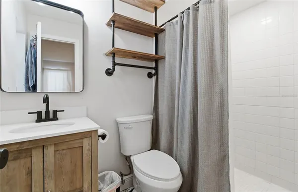 a bathroom with a toilet sink vanity and mirror