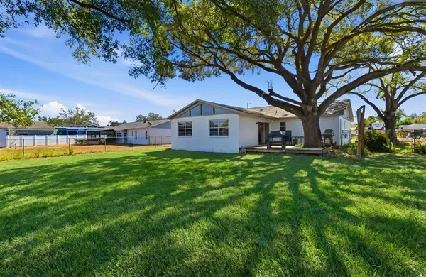 a view of a house with a big yard and large trees