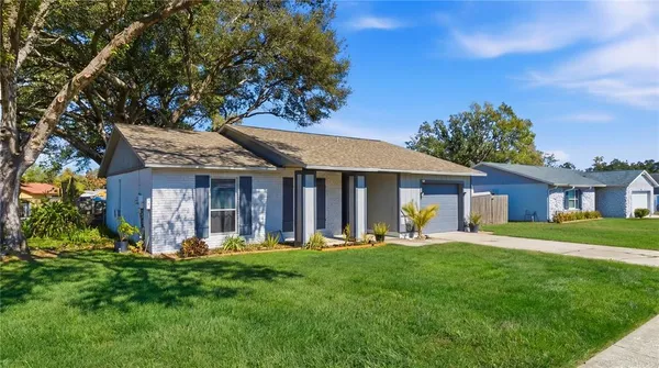 a front view of a house with a yard and trees