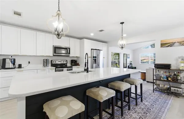 a large kitchen with kitchen island a dining table chairs and a sink