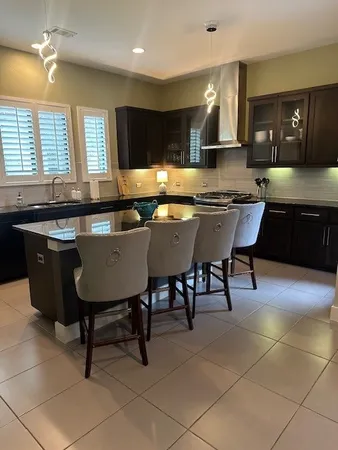 a kitchen with a table chairs sink and cabinets