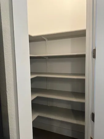 a view of walk in closet with empty racks