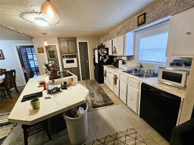 a kitchen with a sink a stove a refrigerator and cabinets