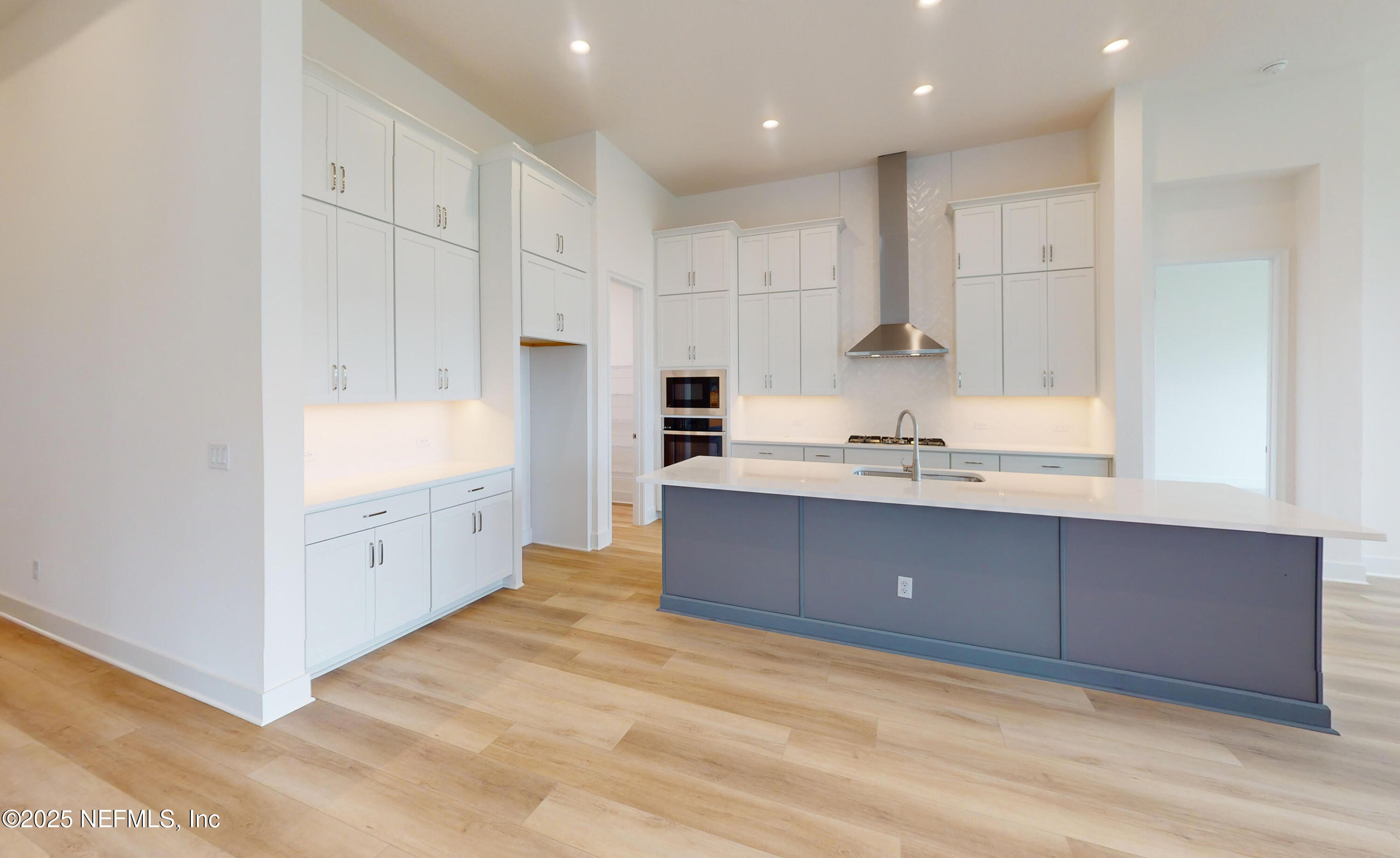 5541 Rainbarrel Road Jacksonville, FL 32224 - Photo 6 of 23 a large white kitchen with kitchen island white cabinets and stainless steel appliances
