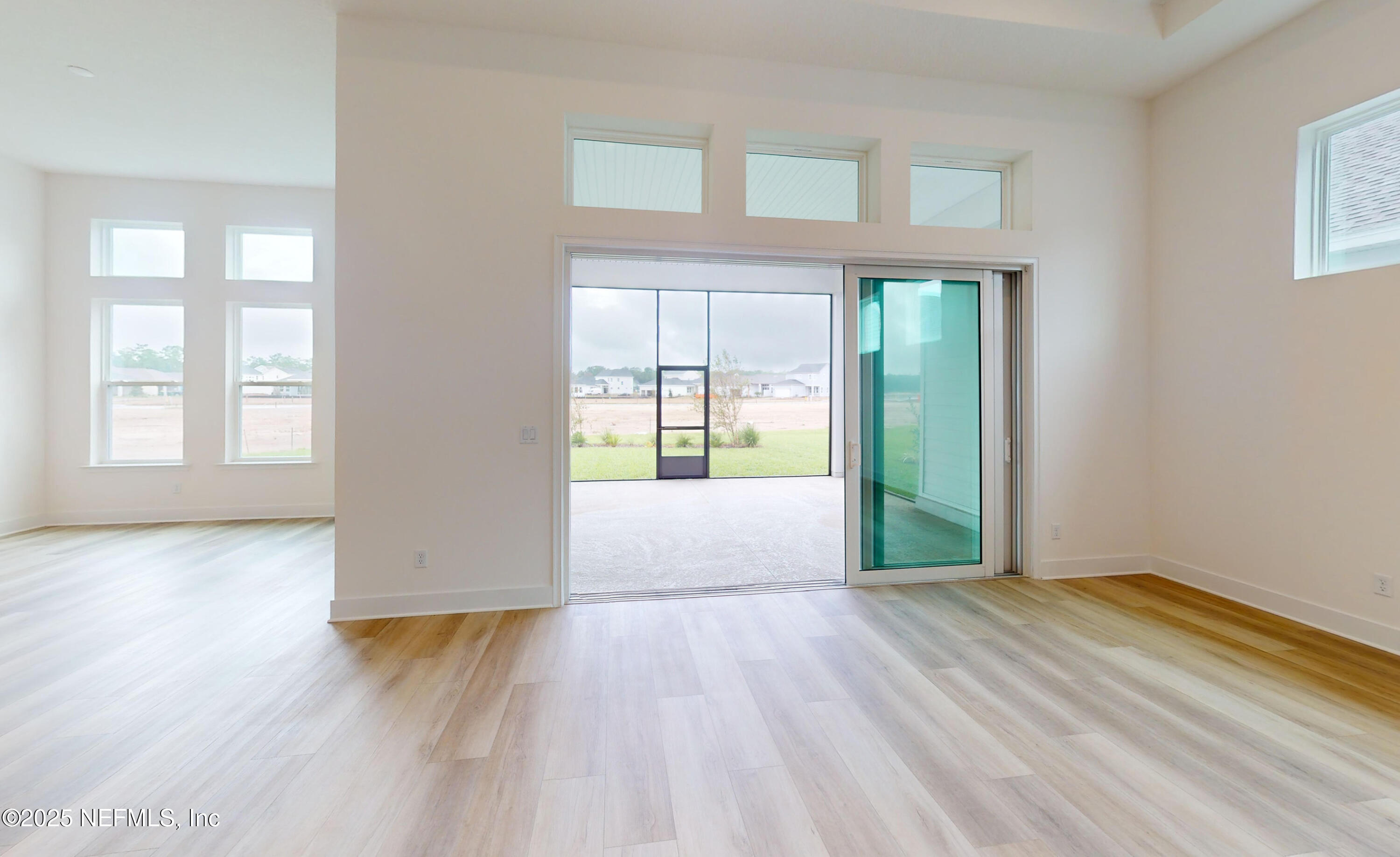 5541 Rainbarrel Road Jacksonville, FL 32224 - Photo 10 of 23 a view of an empty room with wooden floor and a window