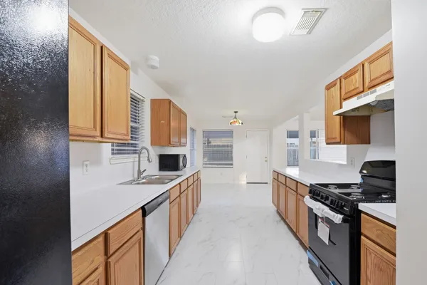 a kitchen with stainless steel appliances granite countertop a stove a sink and a microwave