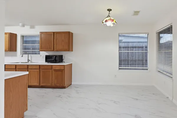 a kitchen with granite countertop a stove a sink dishwasher and a microwave oven