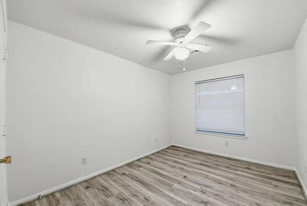 an empty room with a window and wooden floor