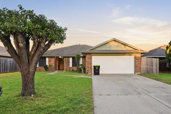 front view of a house with a yard and an trees