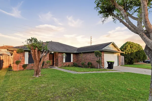 a front view of a house with a yard and trees