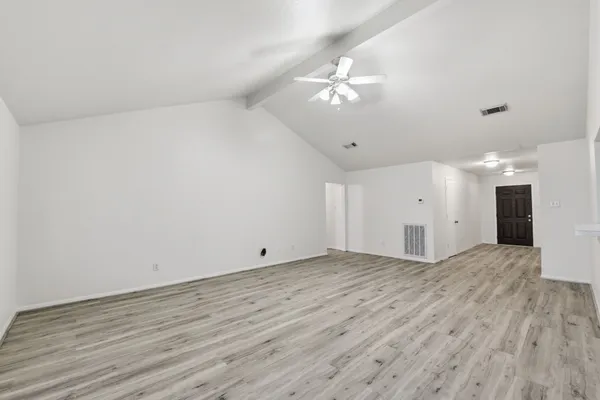 a view of an empty room with wooden floor