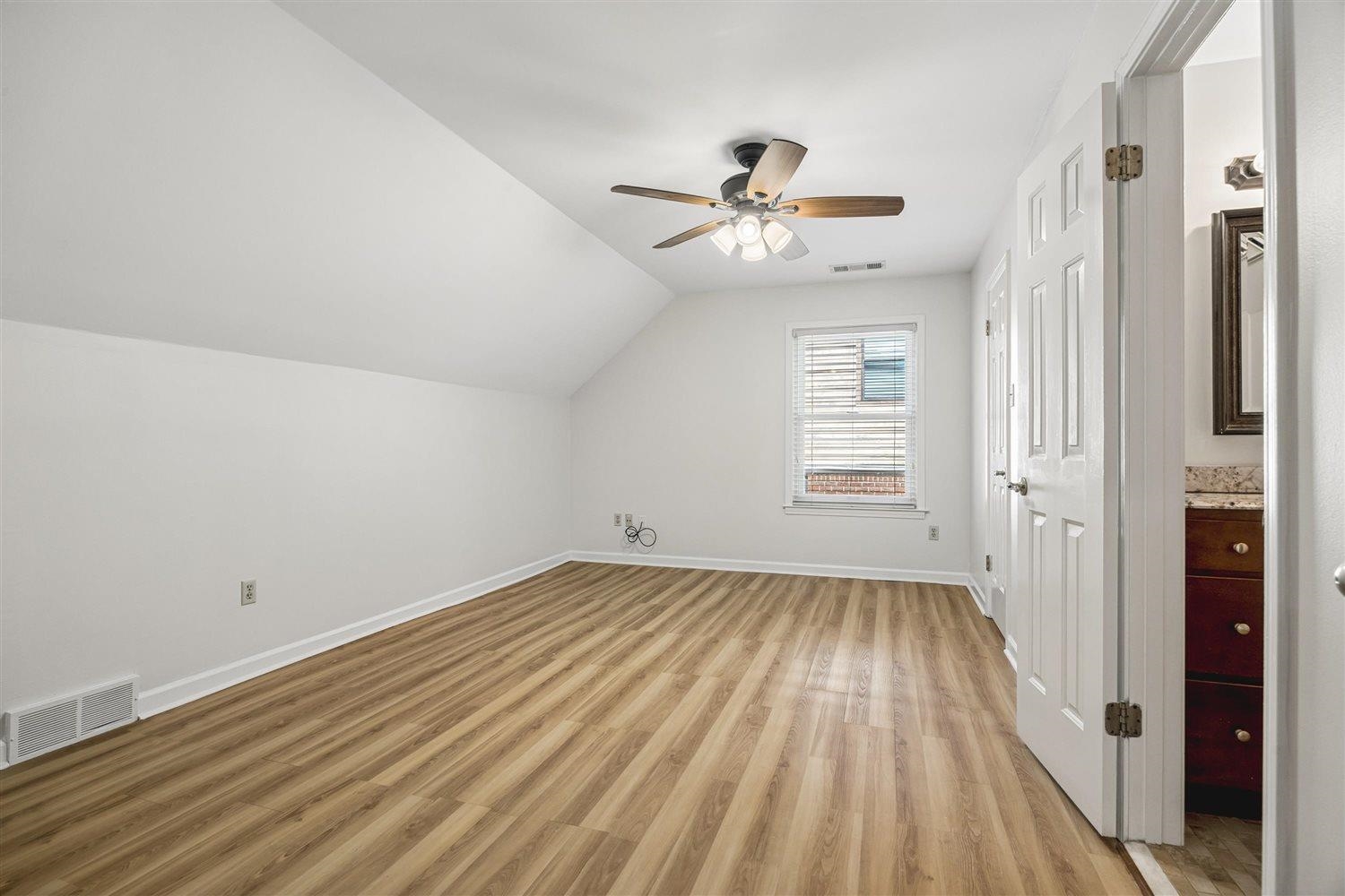 8970 Farmoor Road Germantown, TN 38139 - Photo 22 of 35 Room featuring wood-finish flooring, a sloped ceiling, and a ceiling fan with integrated lighting