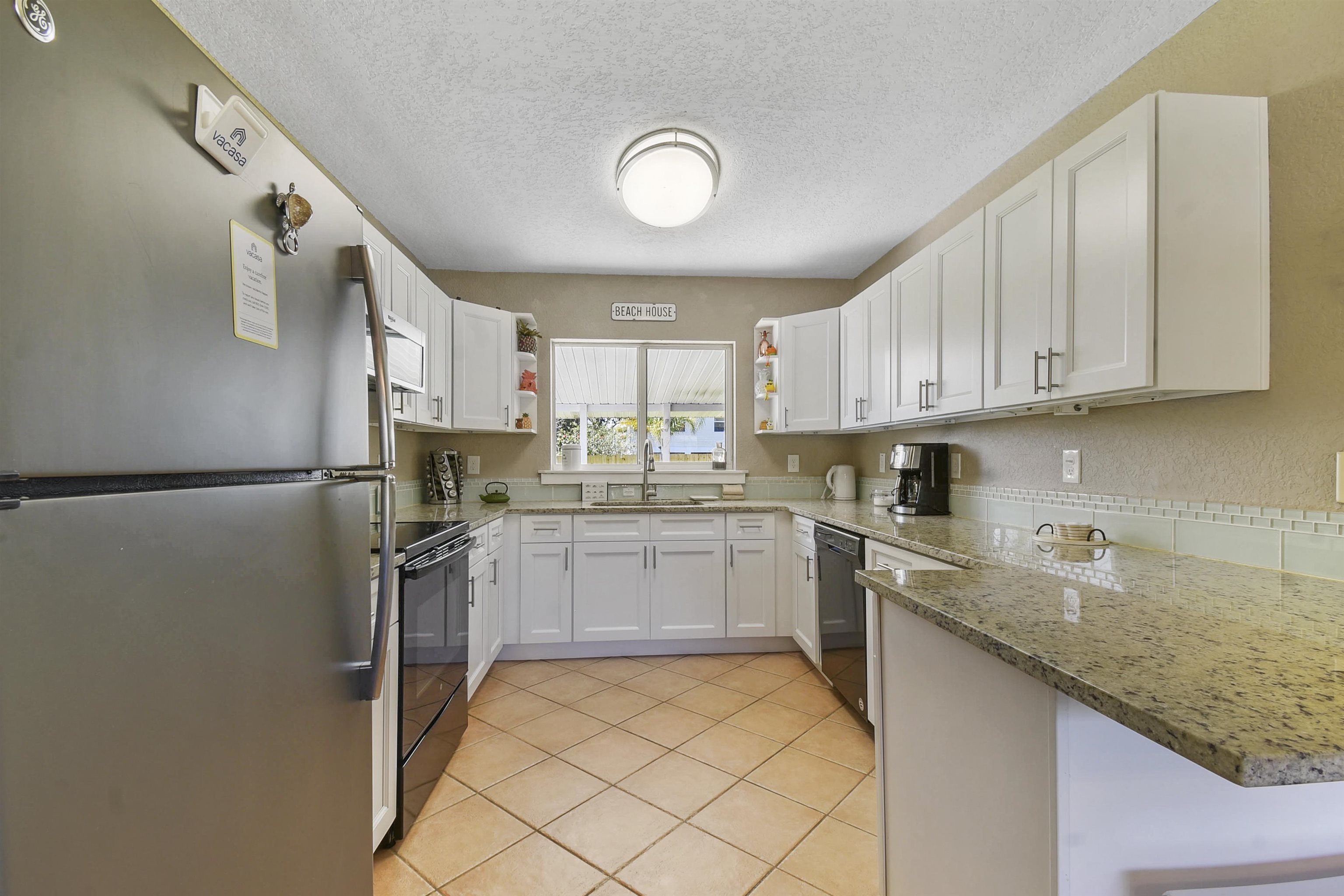 5479 2nd Street St. Augustine, FL 32080 - Photo 9 of 31 a kitchen with a sink window and cabinets