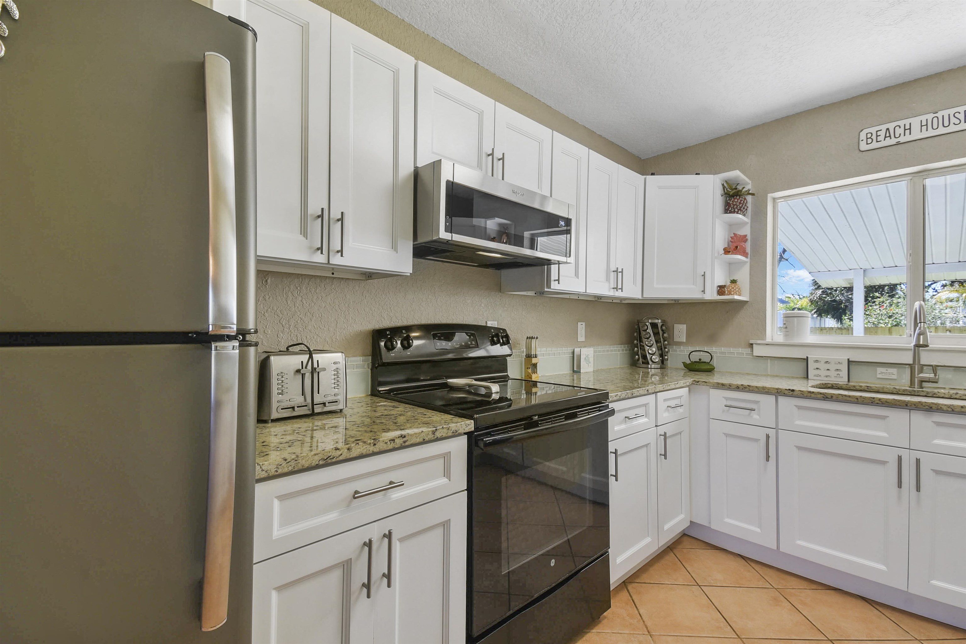 5479 2nd Street St. Augustine, FL 32080 - Photo 10 of 31 a kitchen with stainless steel appliances granite countertop a sink stove refrigerator and cabinets