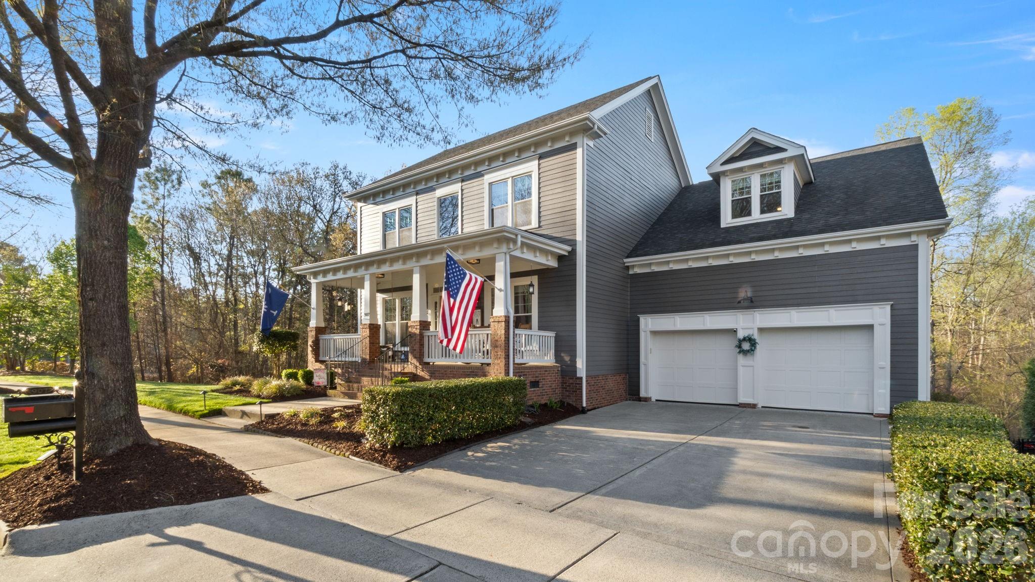907 Derick's Crossing Fort Mill, SC 29708 - Photo 2 of 47 a front view of a house with a yard garage and outdoor seating