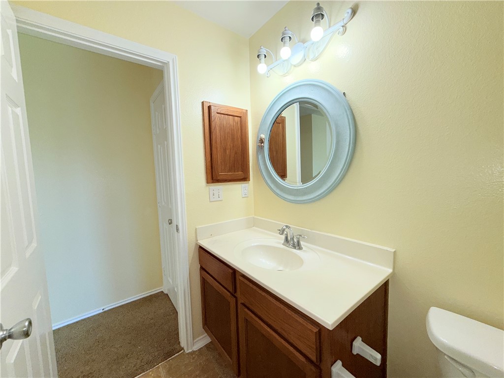 1019 Livermore Street Portland, TX 78374 - Photo 14 of 32 a bathroom with a sink vanity mirror and toilet