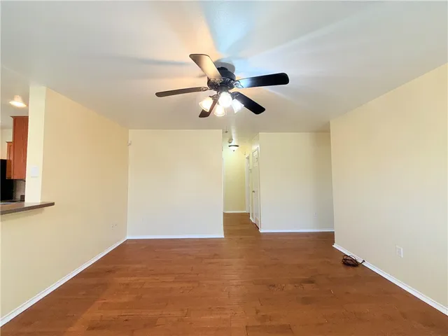 a view of an empty room with chandelier fan and a ceiling fan
