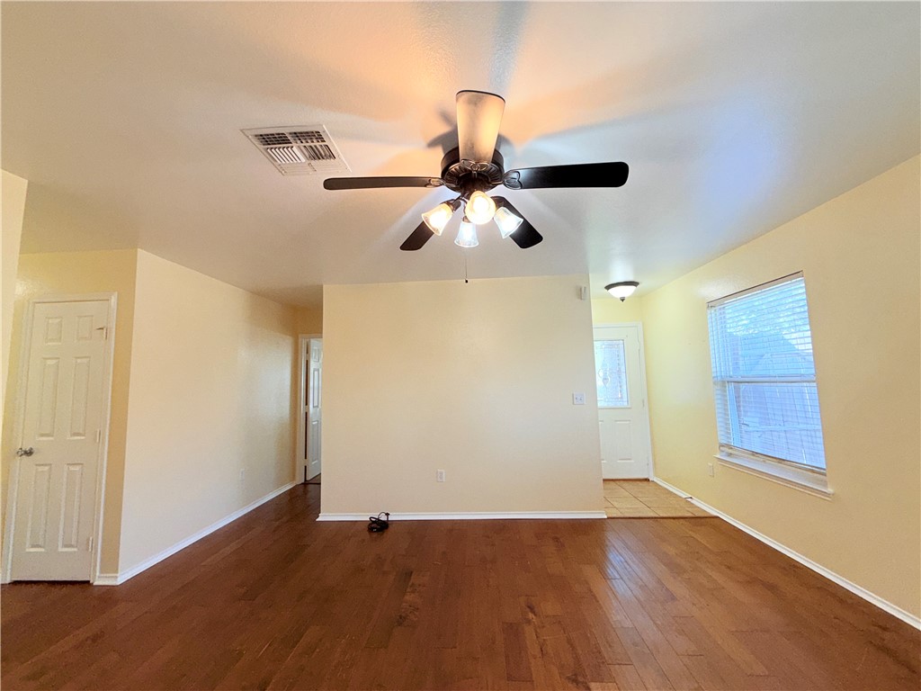 1019 Livermore Street Portland, TX 78374 - Photo 3 of 32 an empty room with wooden floor chandelier fan and windows