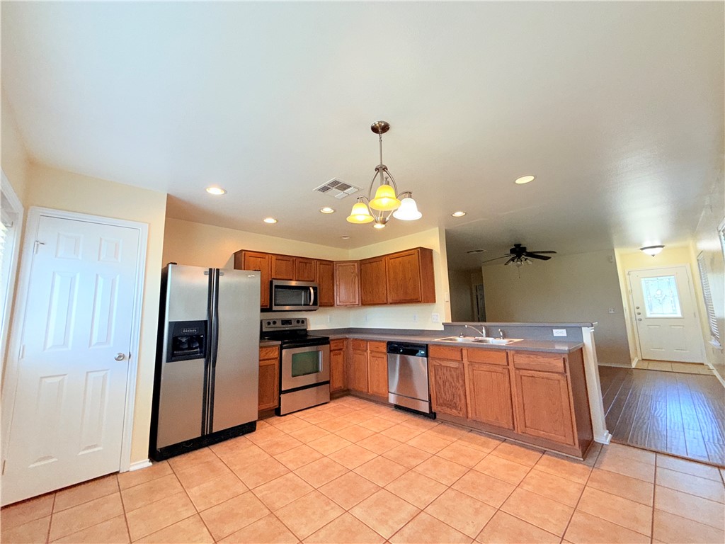 1019 Livermore Street Portland, TX 78374 - Photo 6 of 32 a kitchen with stainless steel appliances a sink and a refrigerator