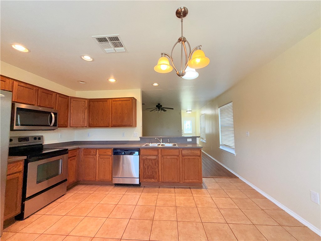 1019 Livermore Street Portland, TX 78374 - Photo 7 of 32 a kitchen with stainless steel appliances granite countertop a sink and cabinets