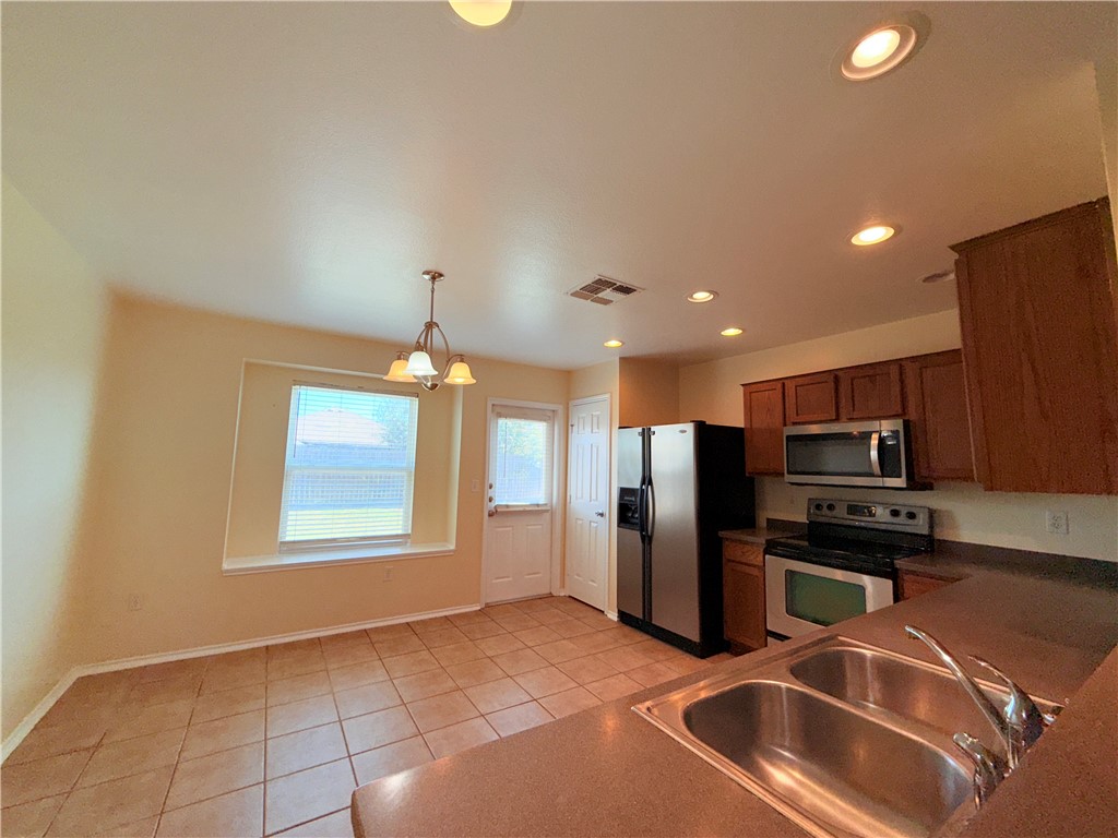 1019 Livermore Street Portland, TX 78374 - Photo 9 of 32 a kitchen with stainless steel appliances a refrigerator sink and microwave