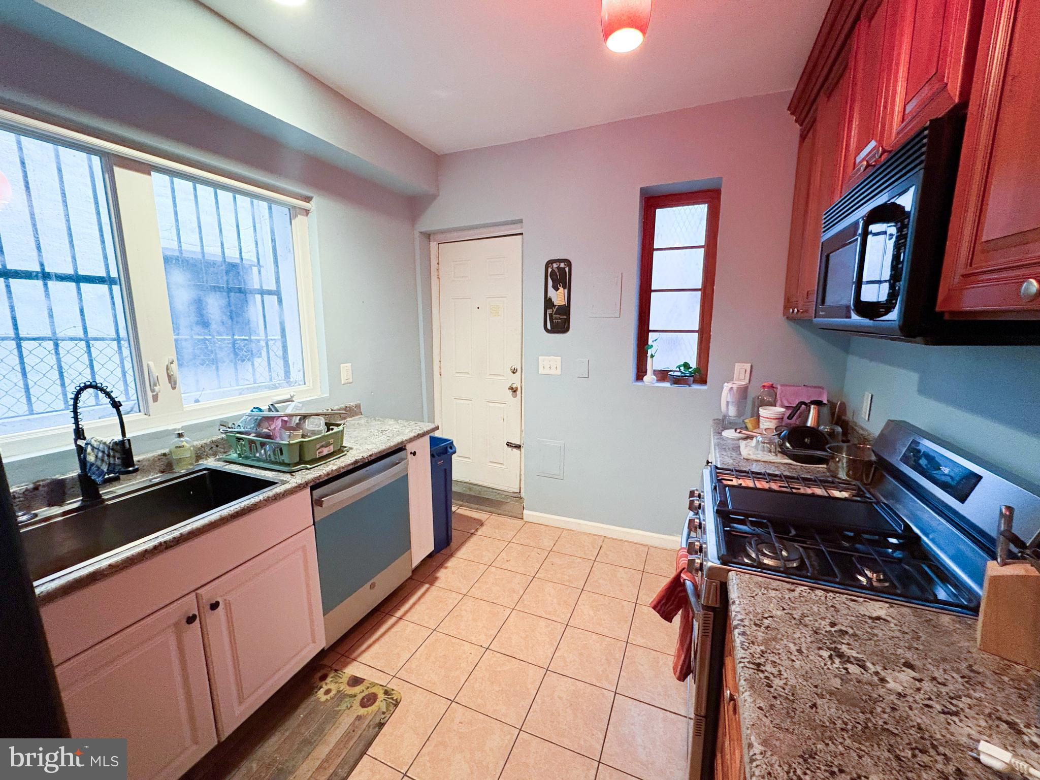 754 Dolphin Street Baltimore, MD 21217 - Photo 6 of 23 a kitchen with stainless steel appliances granite countertop a sink stove and cabinets