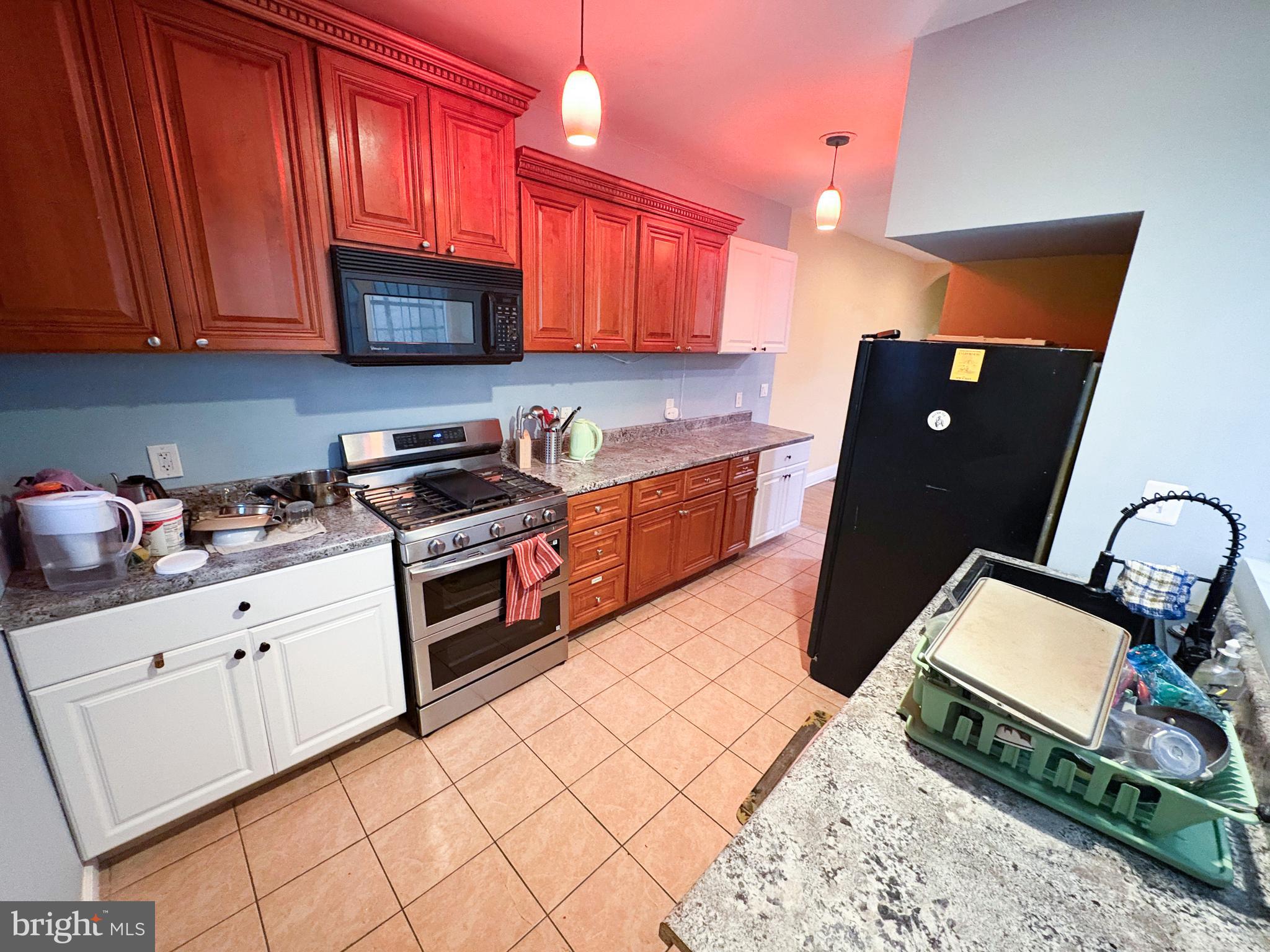 754 Dolphin Street Baltimore, MD 21217 - Photo 7 of 23 a kitchen with stainless steel appliances granite countertop a stove top oven a sink dishwasher and cabinets with wooden floor