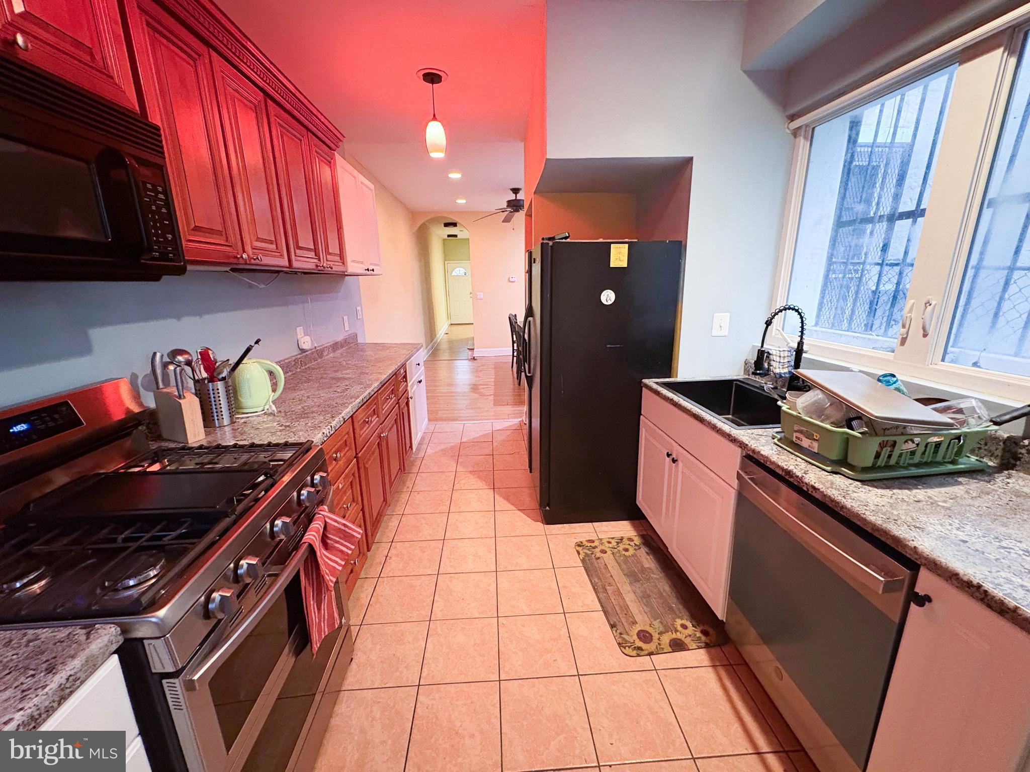 754 Dolphin Street Baltimore, MD 21217 - Photo 8 of 23 a kitchen with stainless steel appliances granite countertop a stove a sink and a microwave