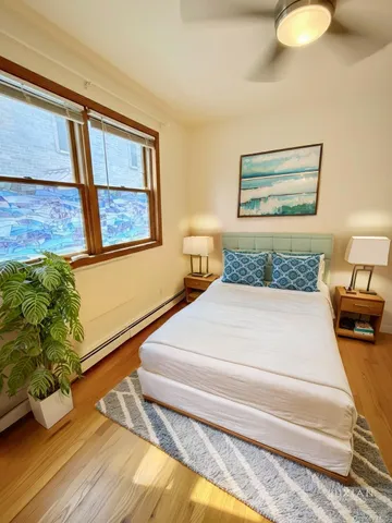 a bedroom with a bed and a painting on the wall