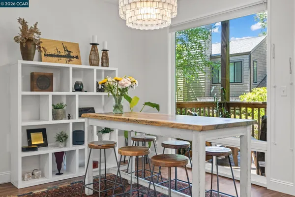 a kitchen with stainless steel appliances granite countertop a stove top oven a sink a refrigerator and white cabinets with wooden floor