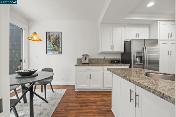 a kitchen with stainless steel appliances granite countertop a stove a sink and white cabinets