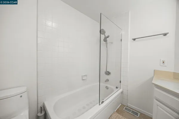 a view of house with wooden fence and potted plants