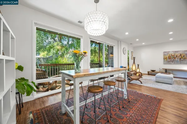 a view of a dining room with furniture a rug and wooden floor