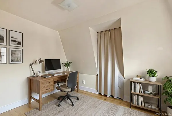 a view of a workspace with furniture and a window