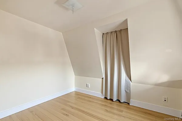 an empty room with wooden floor and a window