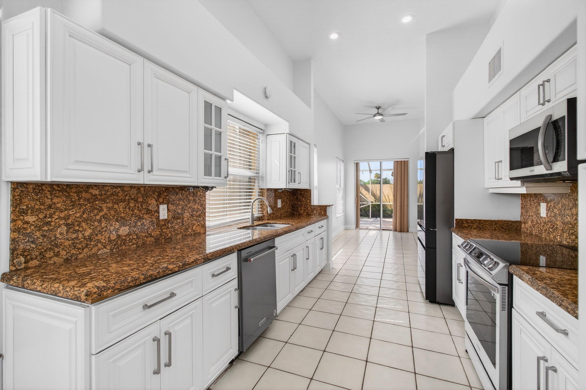 7848 Travelers Tree Drive Boca Raton, FL 33433 - Photo 16 of 60 a large kitchen with stainless steel appliances granite countertop a stove and a sink
