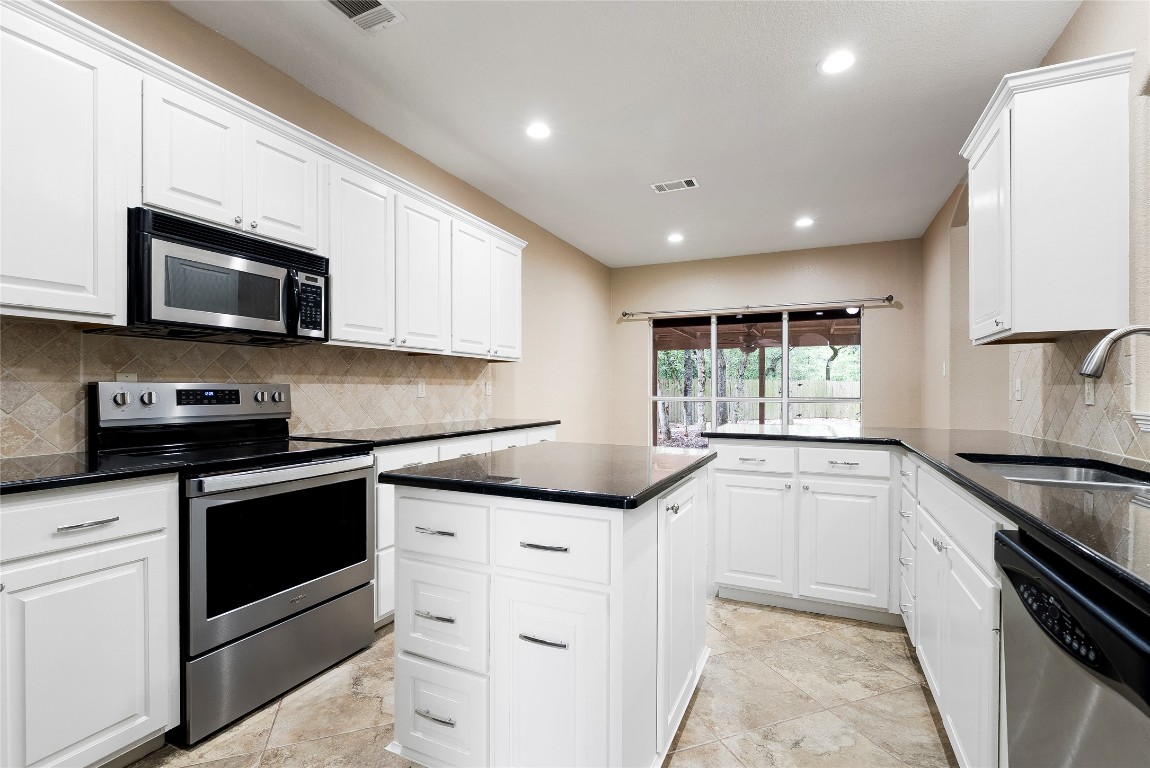 230 Cedar Hills Drive Elgin, TX 78621 - Photo 2 of 40 a kitchen with granite countertop a sink stainless steel appliances and white cabinets