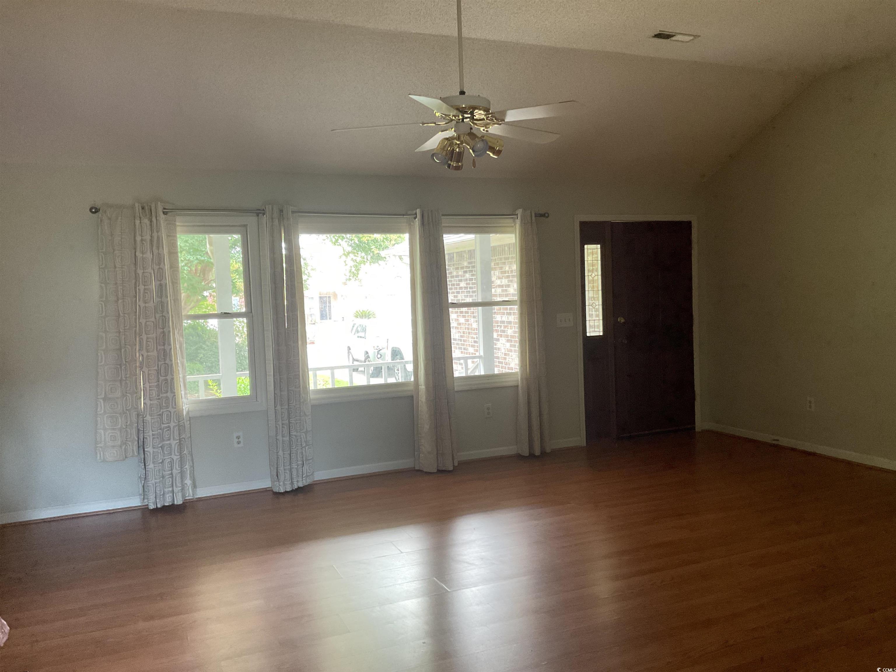 617 Waccamaw River Road Myrtle Beach, SC 29588 - Photo 3 of 17 Unfurnished room with a ceiling fan, wood finished