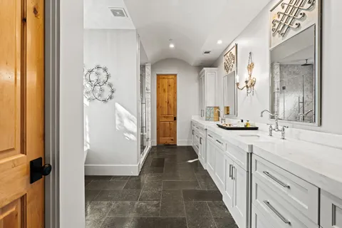 a large white bathroom with a double vanity sink and a mirror