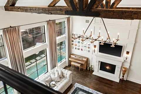 a living room with a fireplace furniture and a floor to ceiling window