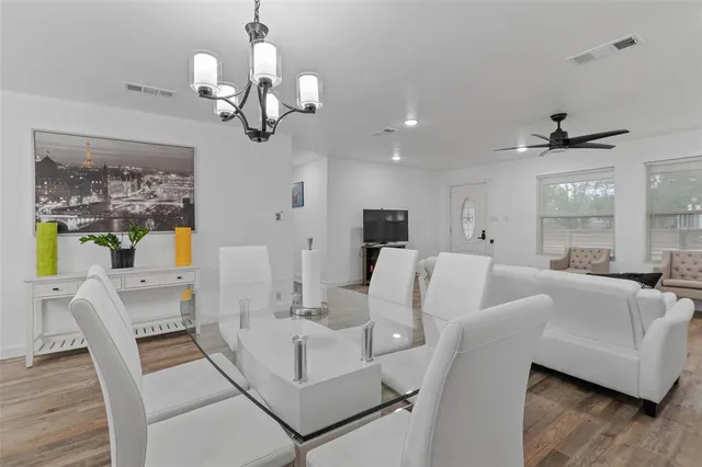 a view of a dining room with furniture a chandelier and wooden floor