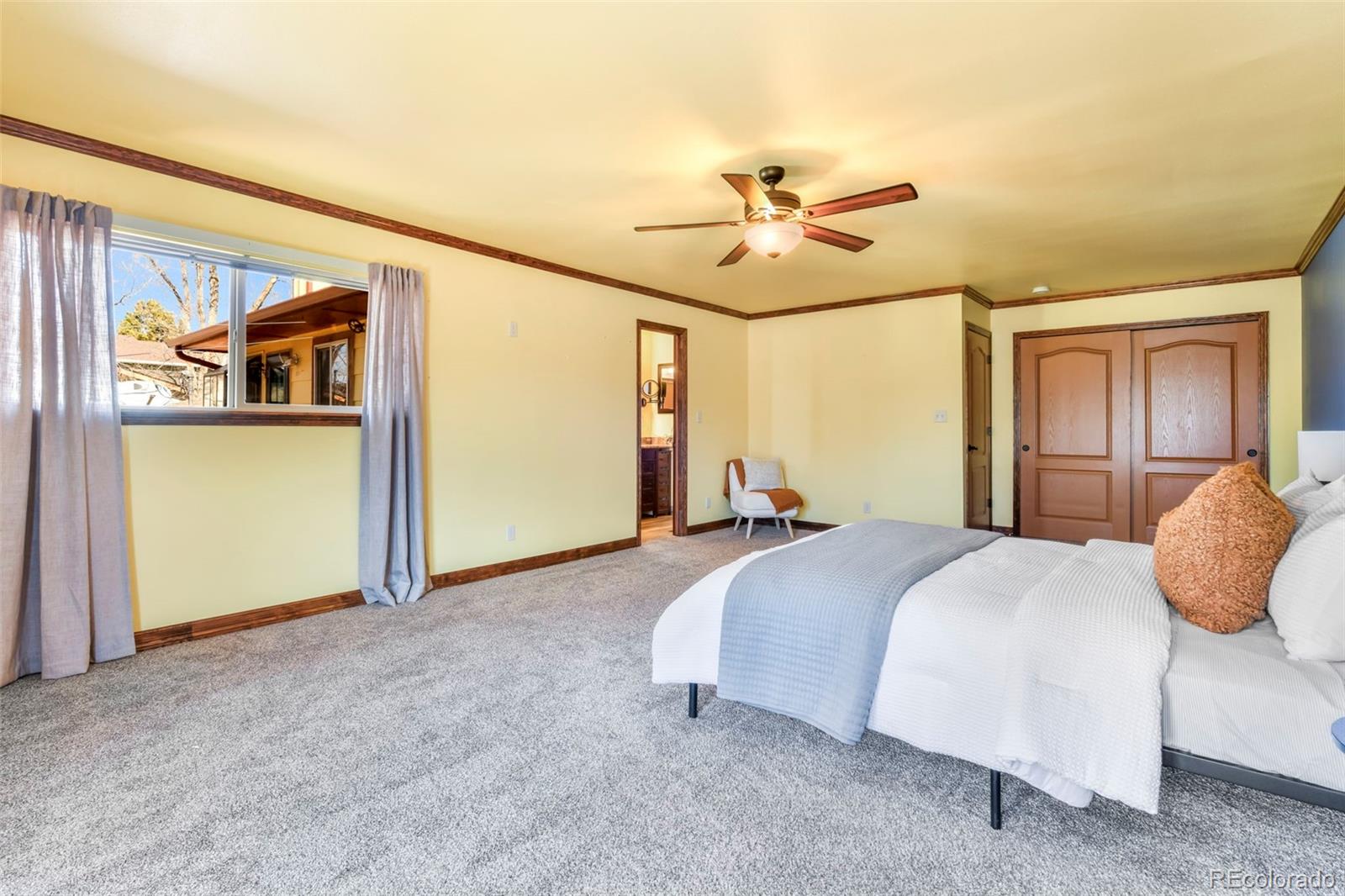 463 Washington Street Monument, CO 80132 - Photo 16 of 50 a spacious bedroom with a bed and a chandelier