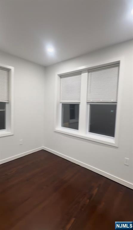 207 Valley Road, Unit 7 Clifton, NJ 07013 - Photo 6 of 8 a view of an empty room with wooden floor and a window