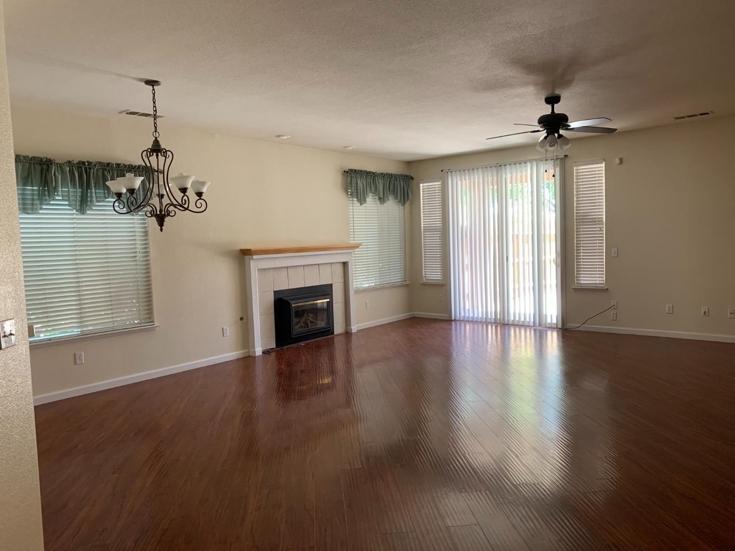3532 Lauding Way Modesto, CA 95355 - Photo 6 of 21 a view of a livingroom with a fireplace wooden floor and chandelier