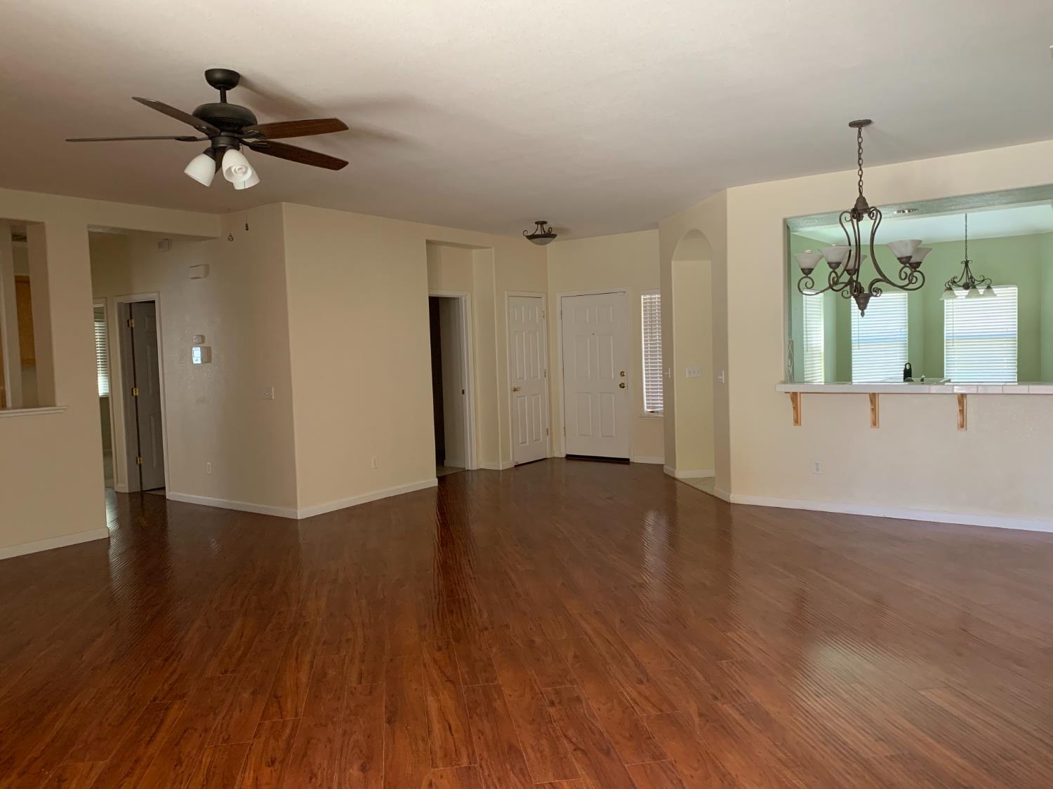 3532 Lauding Way Modesto, CA 95355 - Photo 7 of 21 a view of an empty room with wooden floor and a ceiling fan