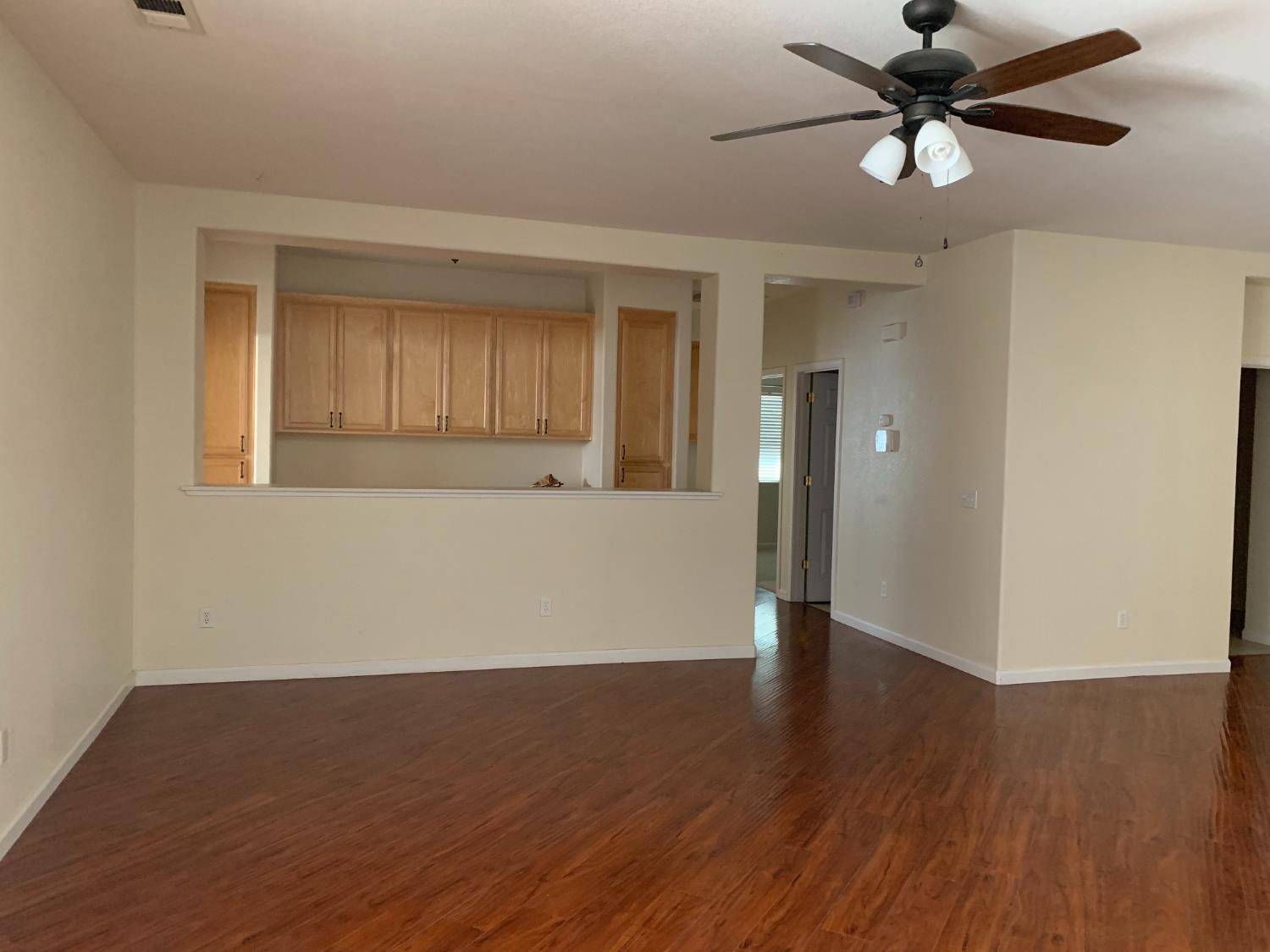 3532 Lauding Way Modesto, CA 95355 - Photo 8 of 21 a view of an empty room with wooden floor and a ceiling fan